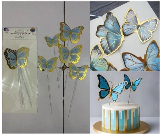 Butterfly cake toppers with gold and blue accents on a cake.