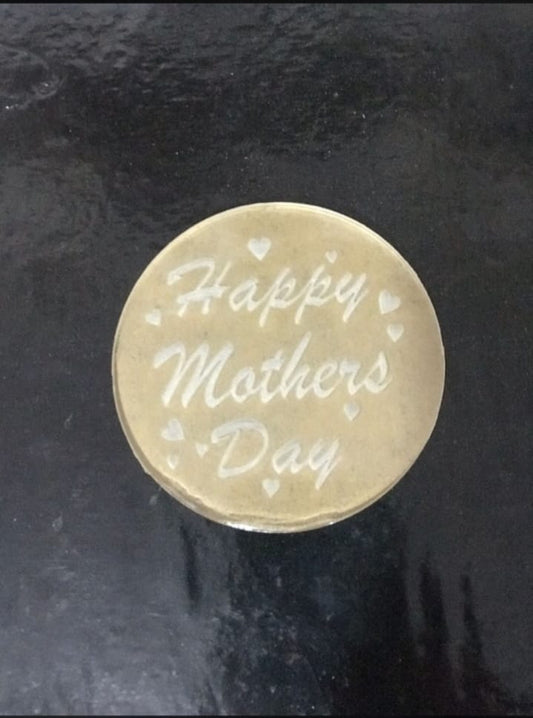 Round gold token with 'Happy Mother's Day' engraving on a dark background