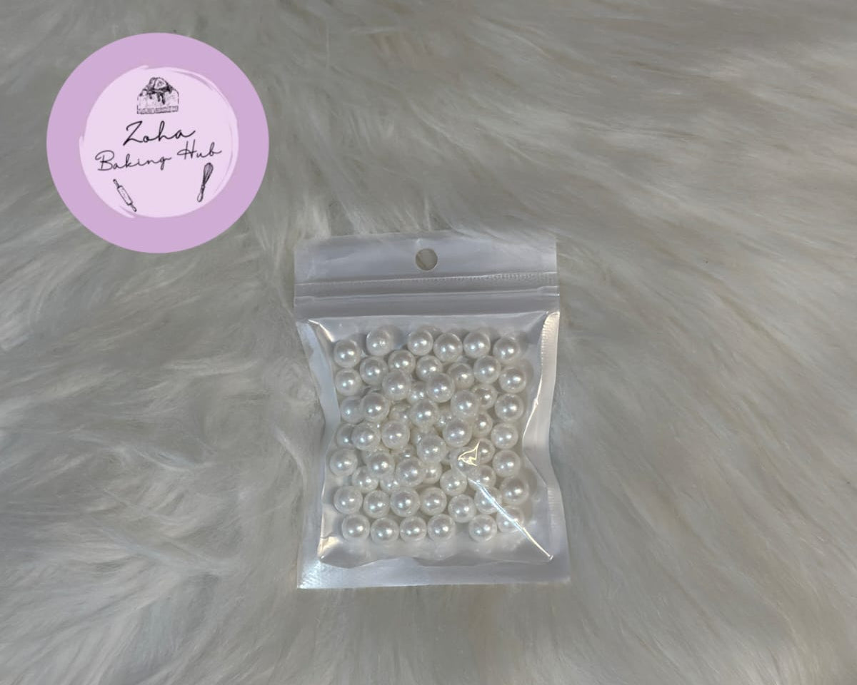 Packaged white pearls on a fur surface with a visible brand label.